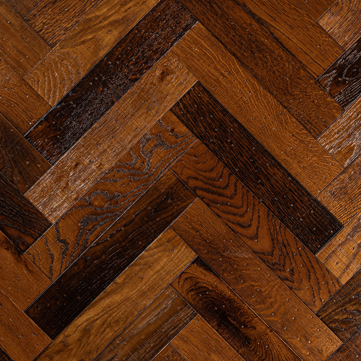 Loudoun Way rustic oak herringbone showing high tonal variation and brushed grain.
