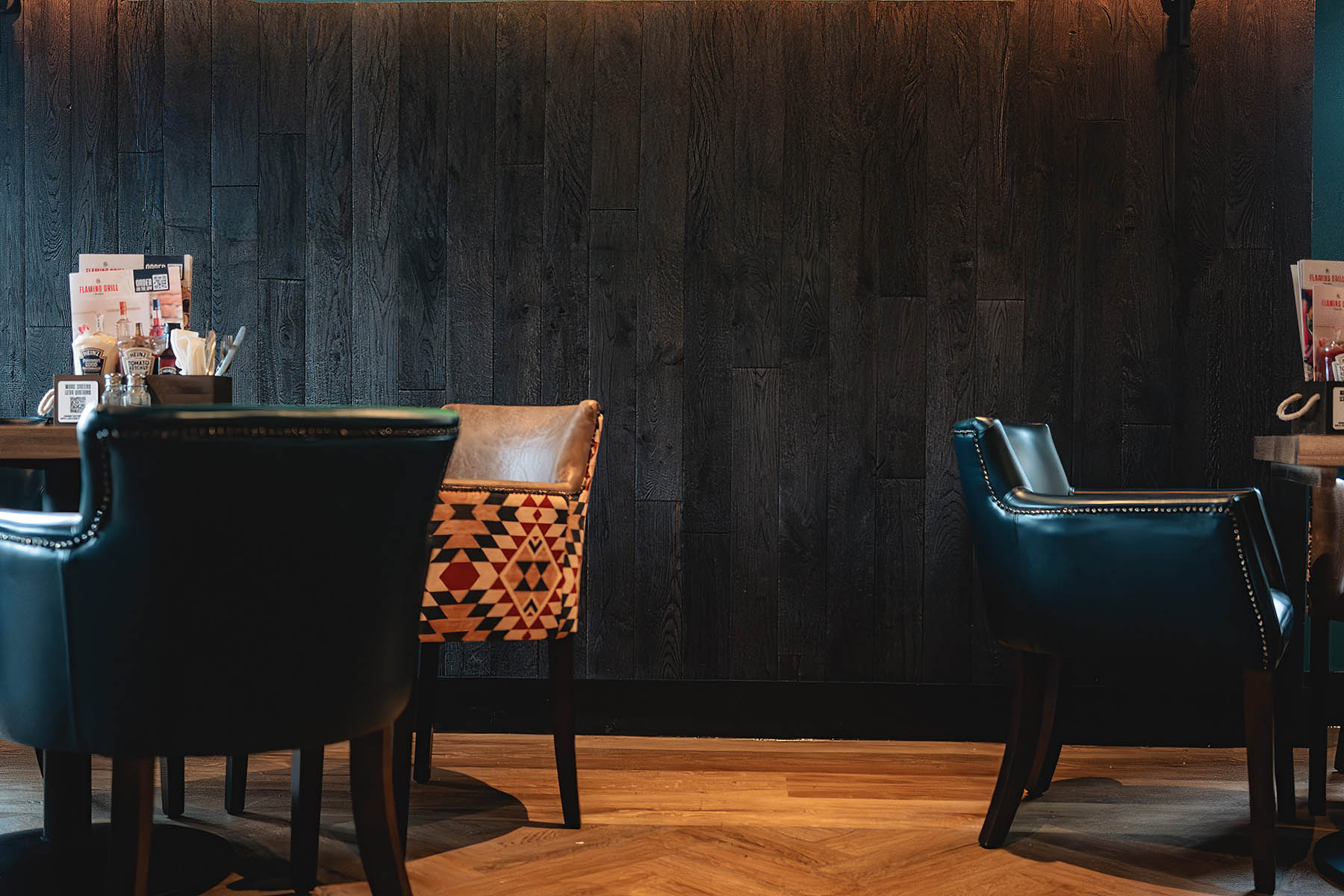 Dark stained oak cladding contrasting with orange banquette seating