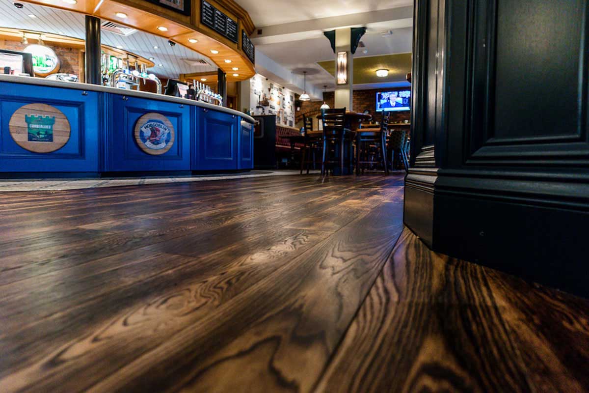 Modern Herringbone engineered wood floor inside an open-plan restaurant.