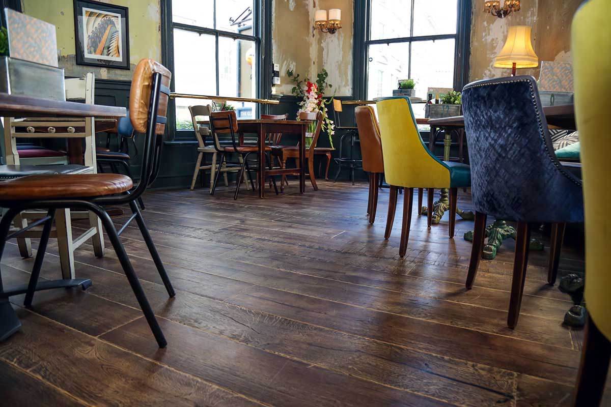 Modern Herringbone engineered wood floor inside an open-plan restaurant.