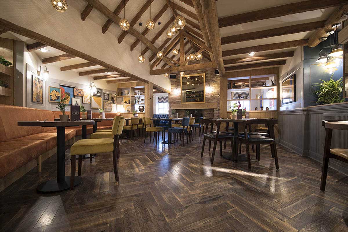 Dark brown, distressed herringbone wood flooring in commercial setting.