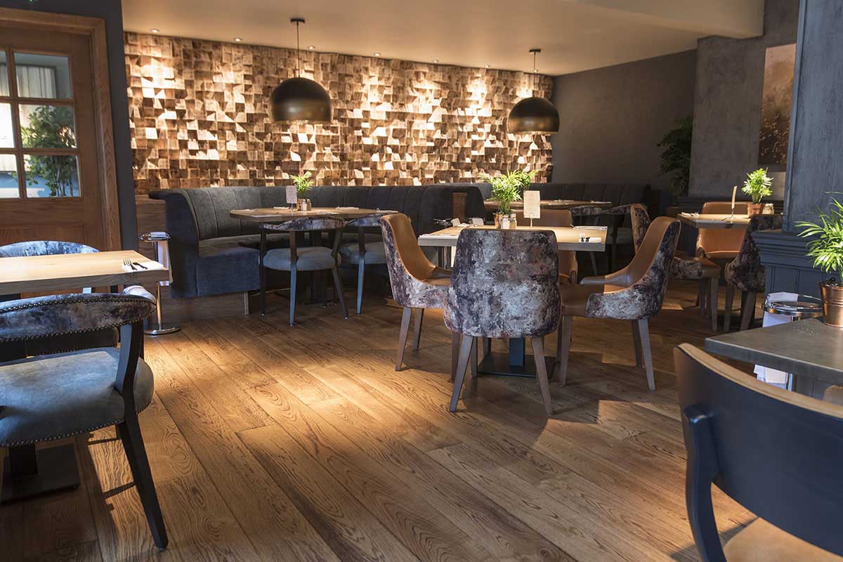 Modern Herringbone engineered wood floor inside an open-plan restaurant.