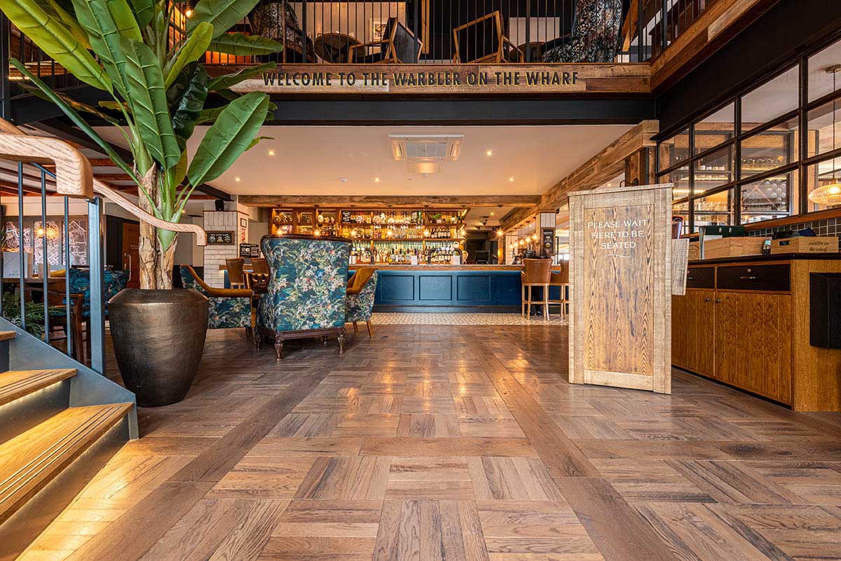 Parquet wood flooring with bespoke detailing in a restaurant.