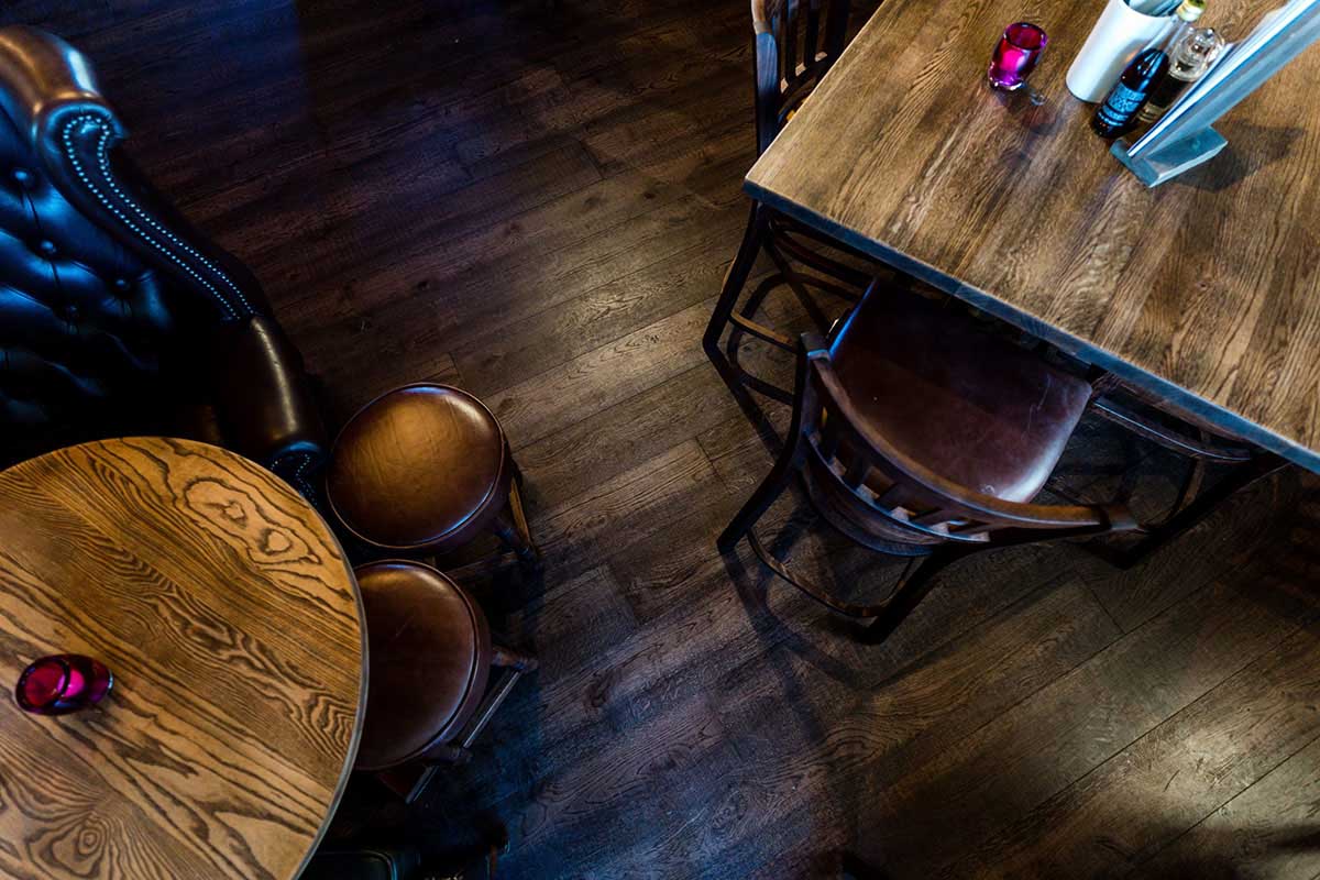 Modern Herringbone engineered wood floor inside an open-plan restaurant.