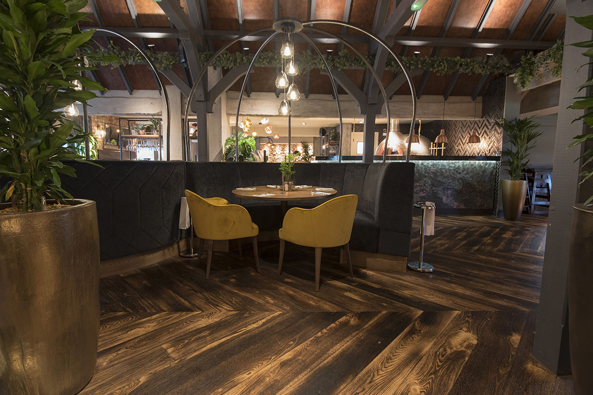 Dark brown, distressed chevron wood flooring in commercial setting.