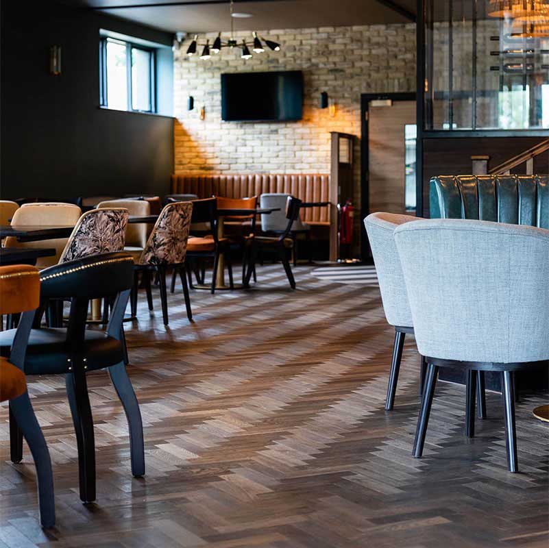 Herringbone wood floor installation in a commercial setting