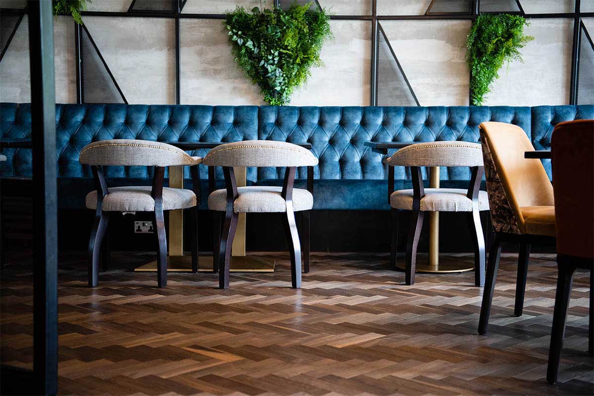 Modern Herringbone engineered wood floor inside an open-plan restaurant.