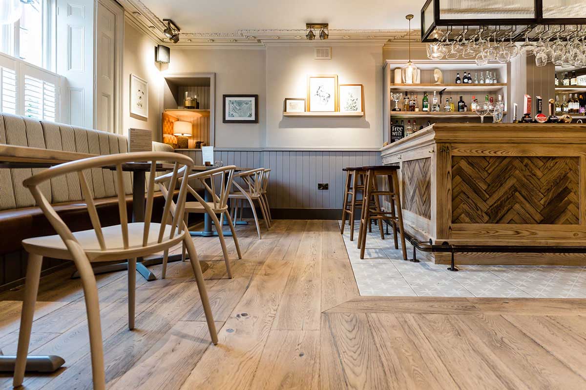 Modern Herringbone engineered wood floor inside an open-plan restaurant.