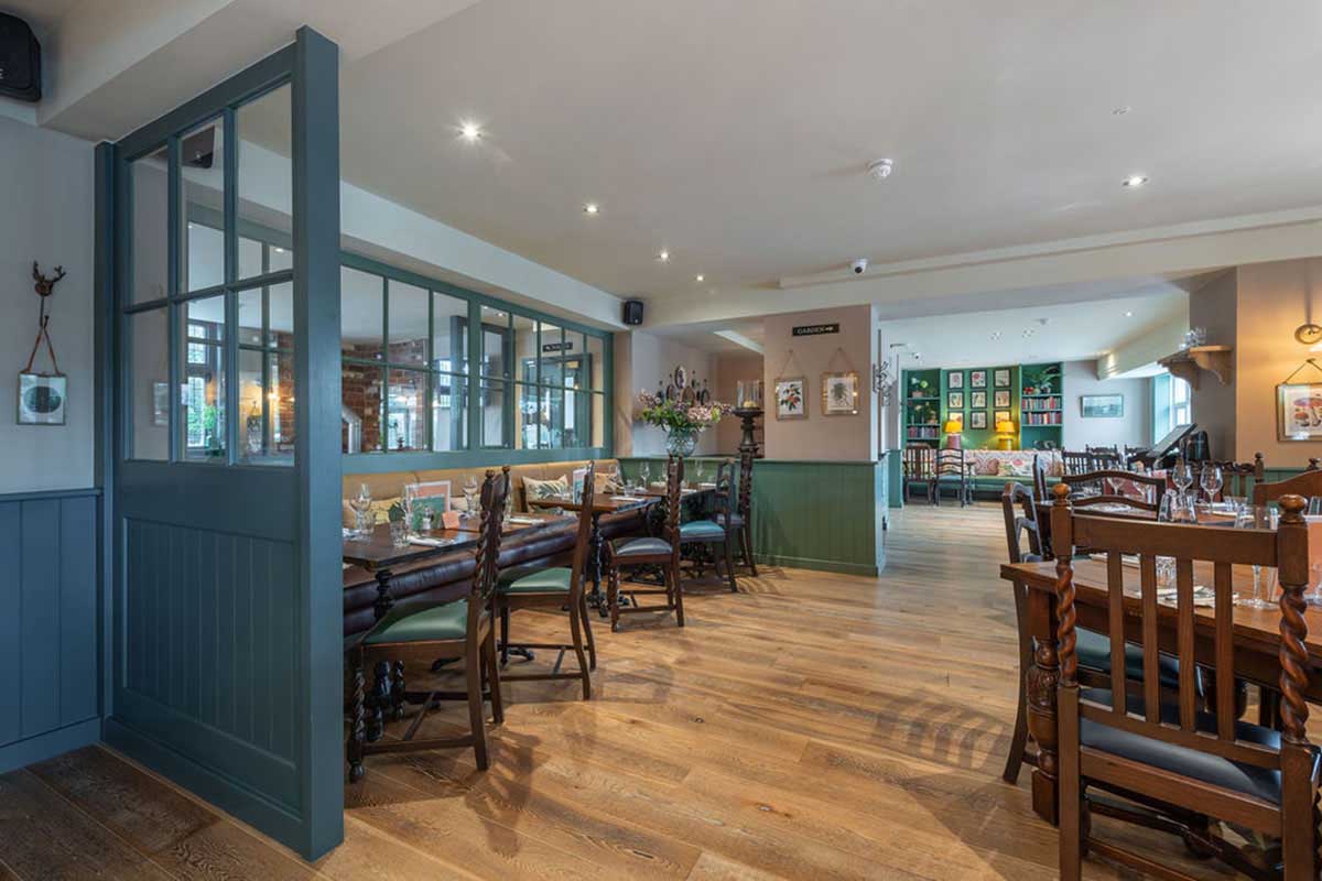 Modern Herringbone engineered wood floor inside an open-plan restaurant.