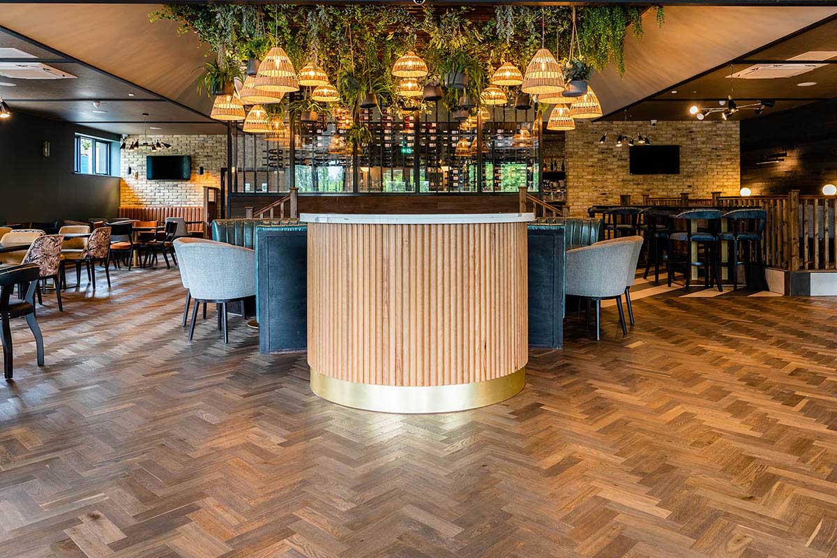 Parquet wood flooring with a Herringbone design in a restaurant.