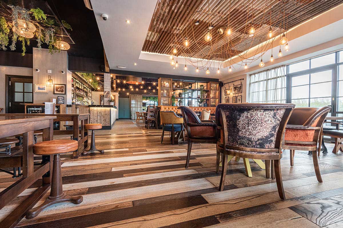 Random width wood flooring with various plank colours in a pub.